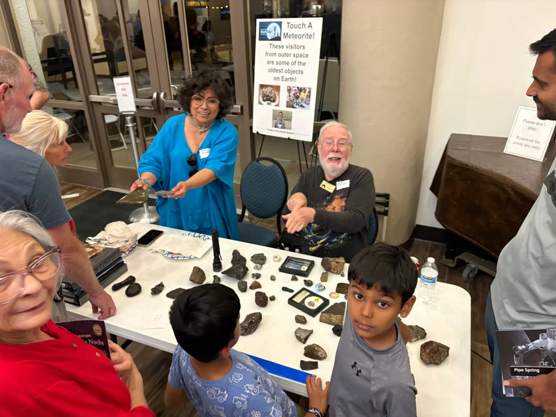 A PAS member holding out a meteorite for visitors to touch at an outreach event